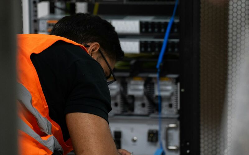 Technician installing server and network equipment